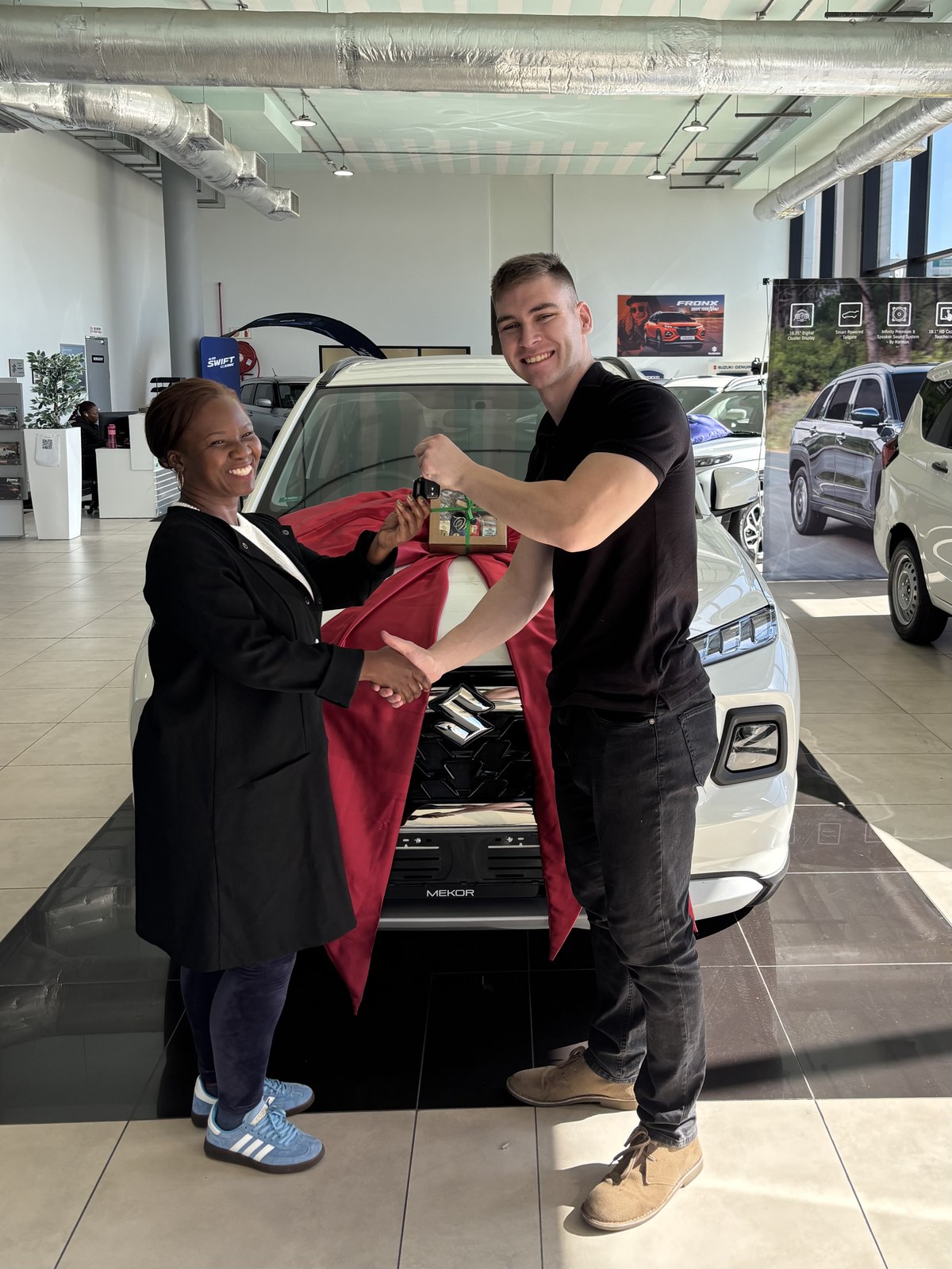 Client receiving keys to a new Suzuki from Jean Joubert