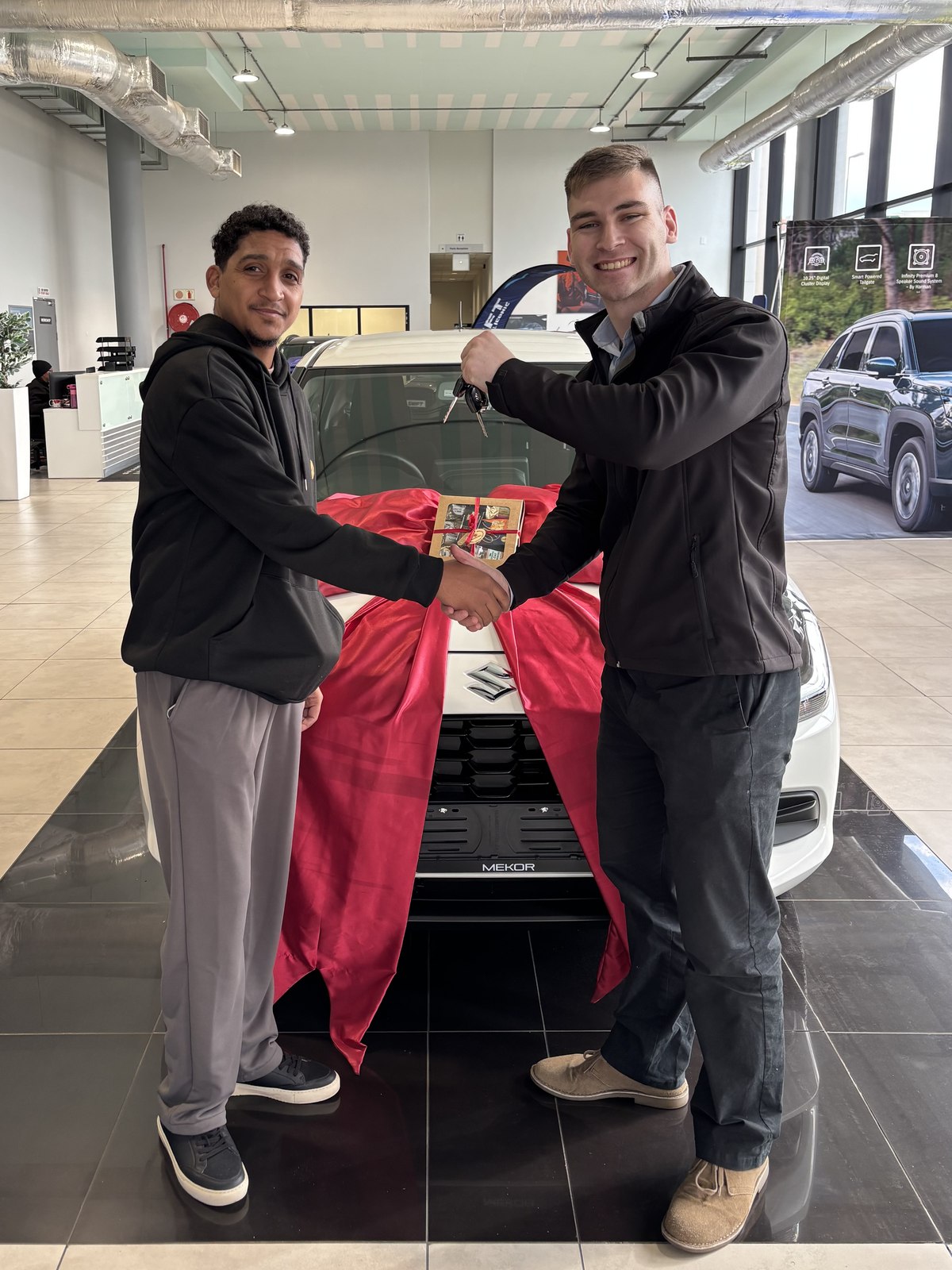 Client receiving keys to a new Suzuki from Jean Joubert