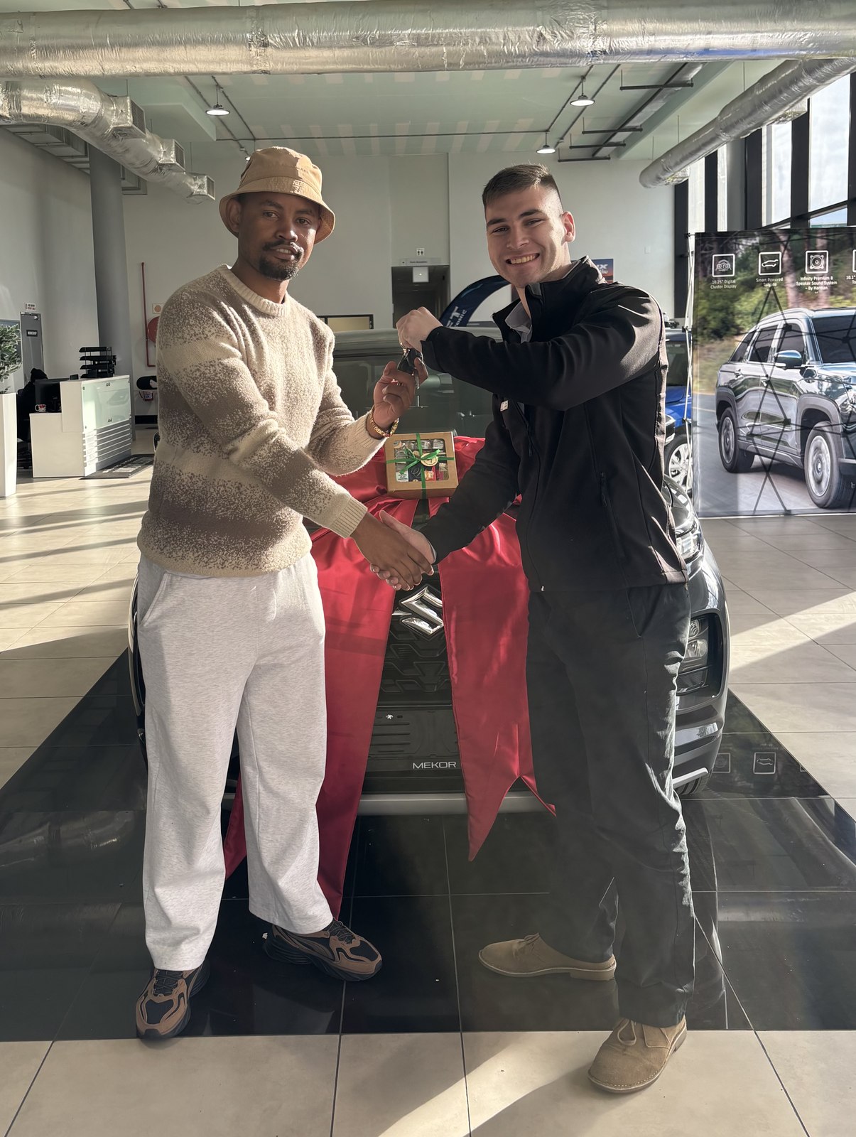 Client receiving keys to a new Suzuki from Jean Joubert