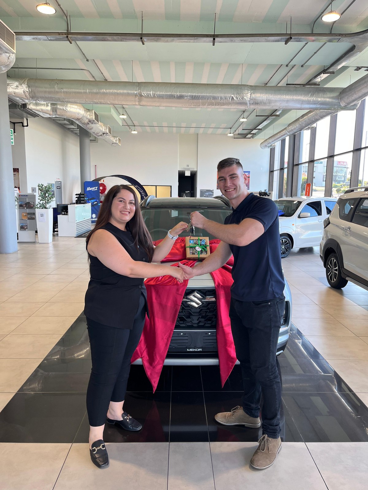 Client receiving keys to a new Suzuki from Jean Joubert
