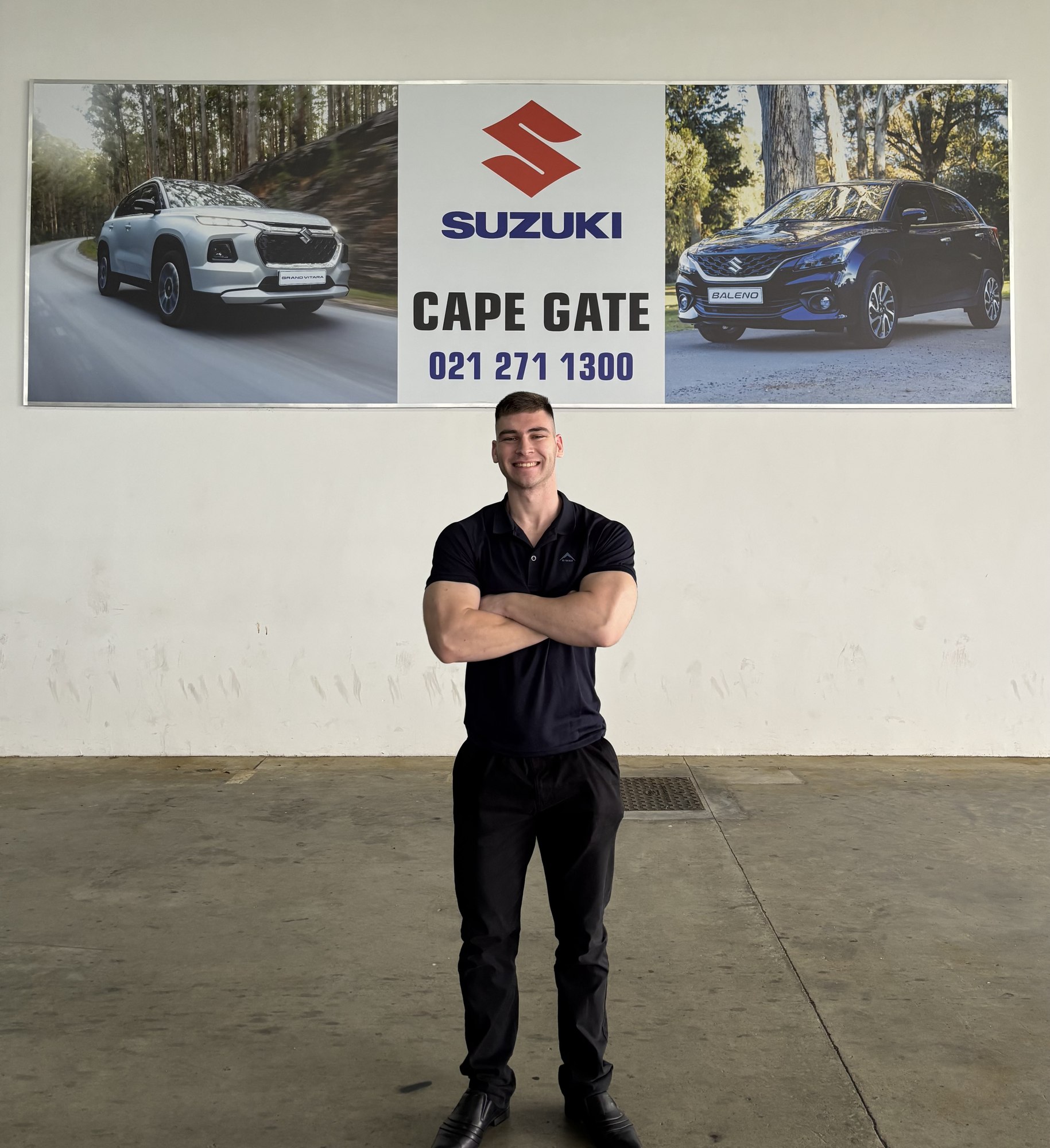 Jean Joubert standing in front of the Mekor Suzuki Cape Gate showroom sign